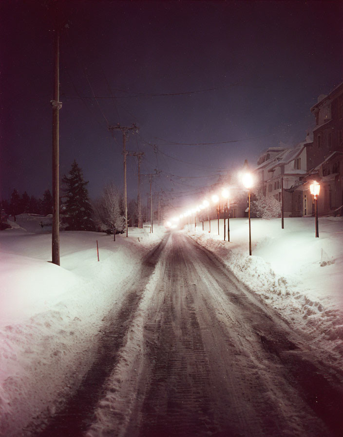 Snowy Night Street Scene with Illuminated Buildings