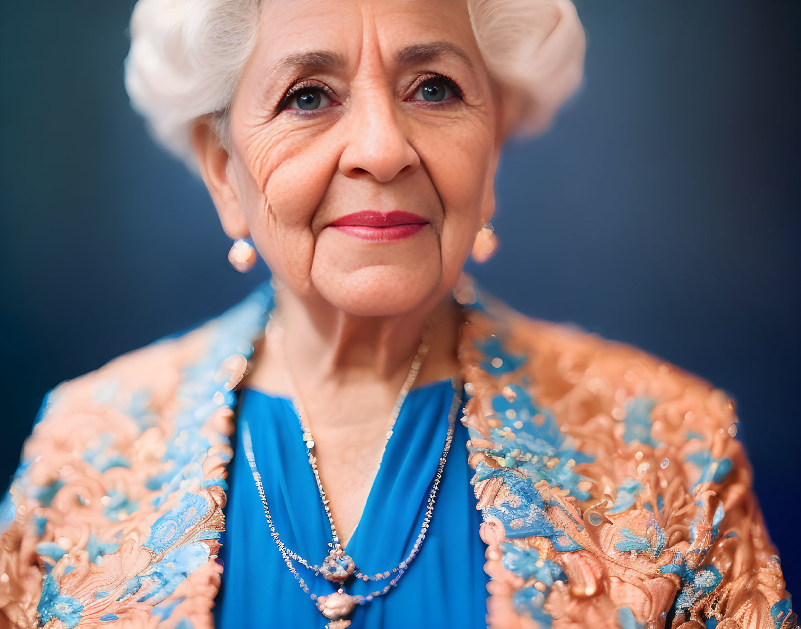 Elderly Woman in Blue Dress and Orange Shawl Smiling