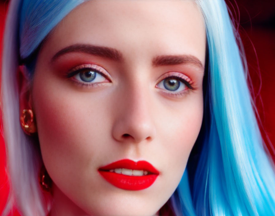 Blue-haired woman with bold red makeup on red backdrop