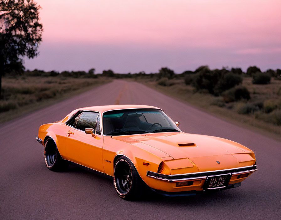 Vintage orange sports car on open road at dusk with purple sky