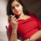 Dark-haired woman in red draped garment holding blue orb in cavernous setting