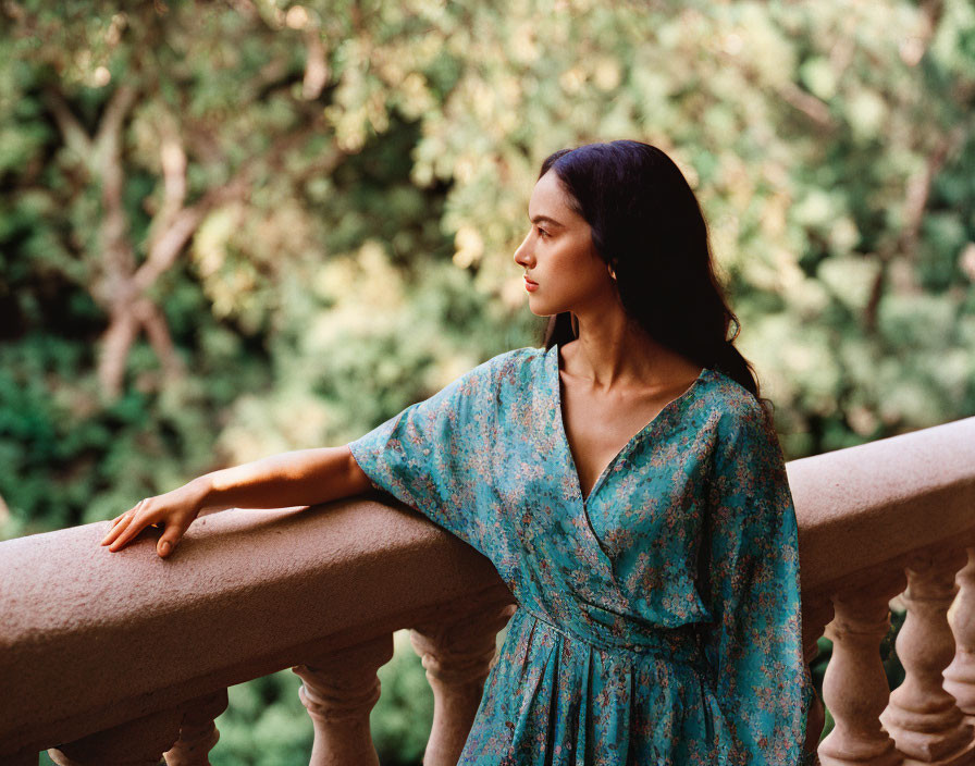 Woman in Blue Dress on Balcony Surrounded by Greenery