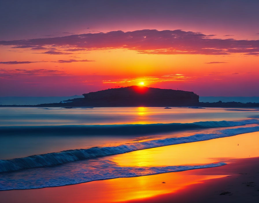 Vibrant sunset over calm ocean with gentle waves and golden reflection.