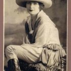 Illustrated woman in ornate clothing and hat against Art Nouveau background.