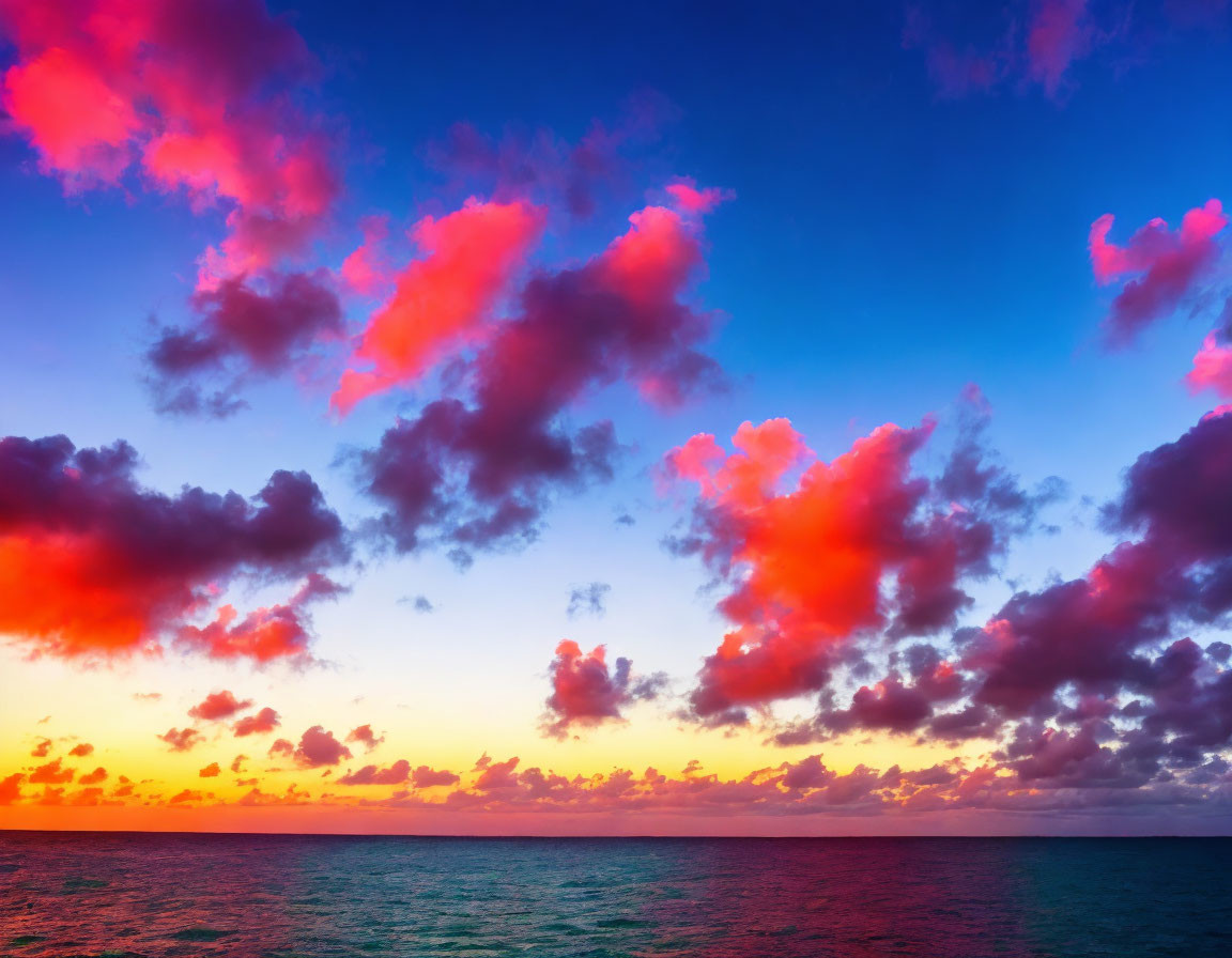 Vibrant pink and orange sunset over calm ocean horizon