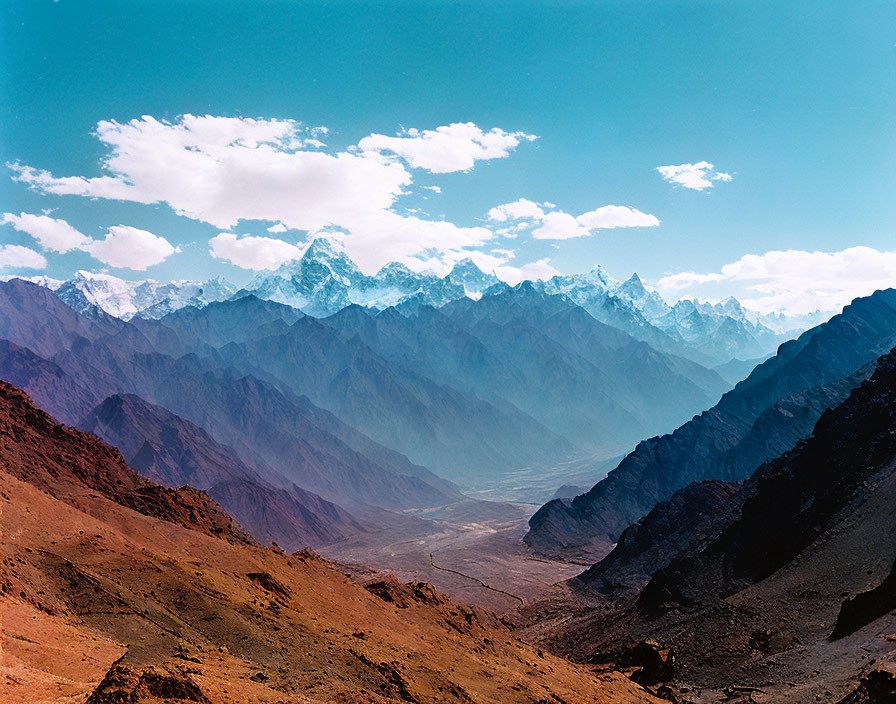 Panoramic view of rugged mountain ranges under blue sky