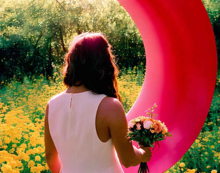 Pink-haired woman in white dress with bouquet in yellow flower field and pink ribbon sculpture