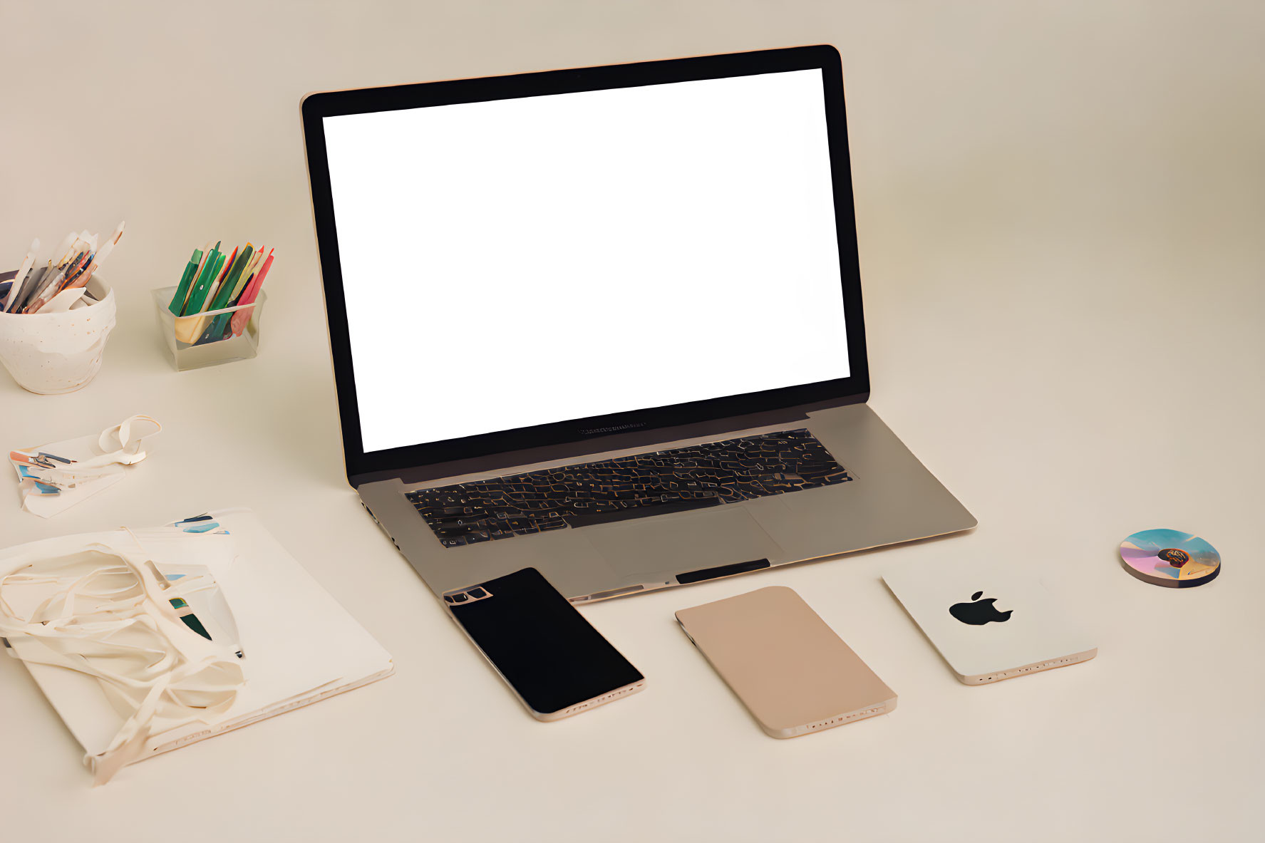 Electronic devices and stationery items on desk setting.