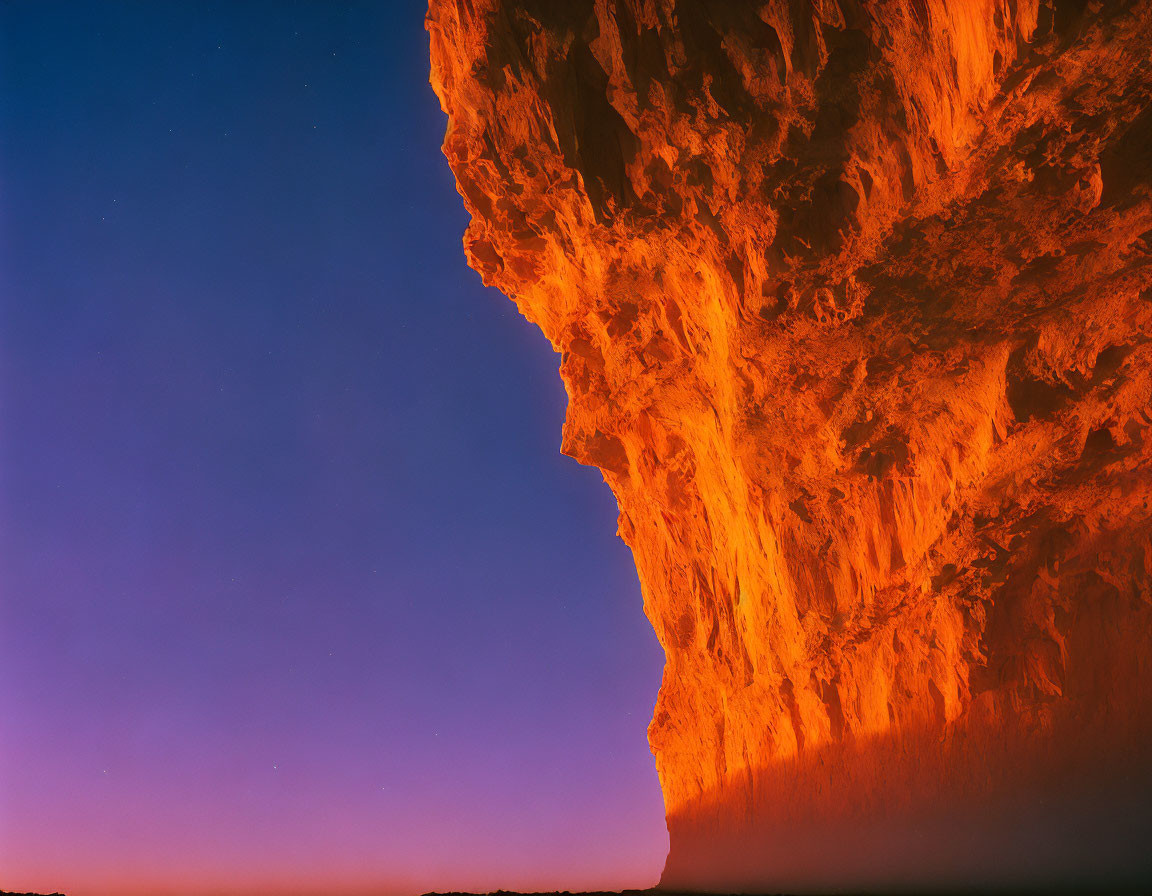 Dramatic cliff at sunset under twilight sky