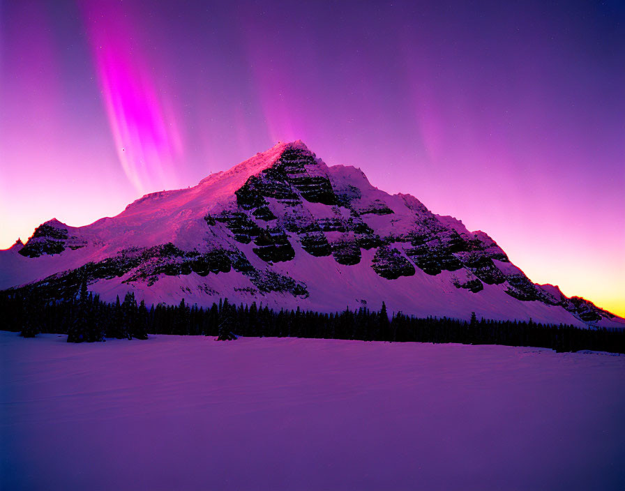 Snowy mountain peak under vibrant aurora borealis at twilight