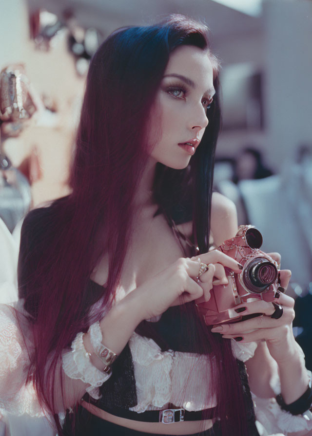 Dark-haired woman in white blouse with vintage camera and black corset