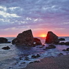 Scenic beach sunset painting with colorful sky & rock formations