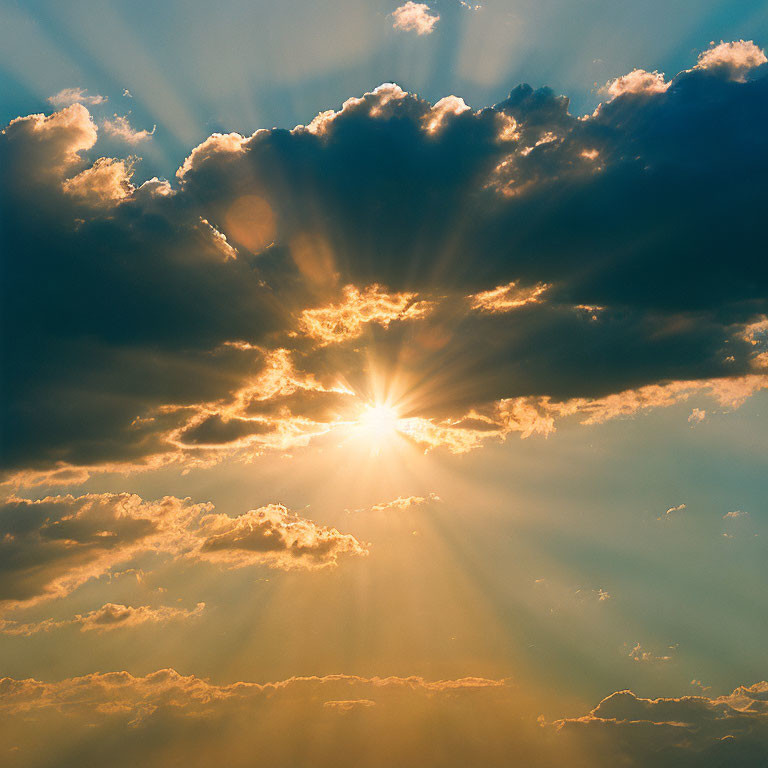 Sunbeams through clouds on blue sky background