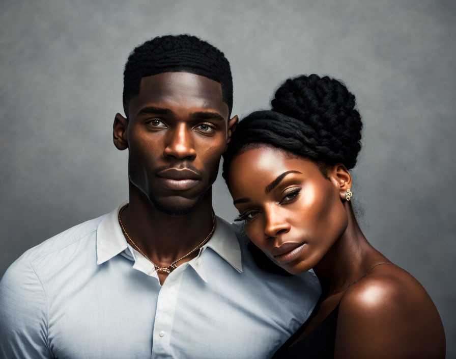 Stylish couple portrait: man in light shirt, woman with elegant updo hairstyle and intense gaz