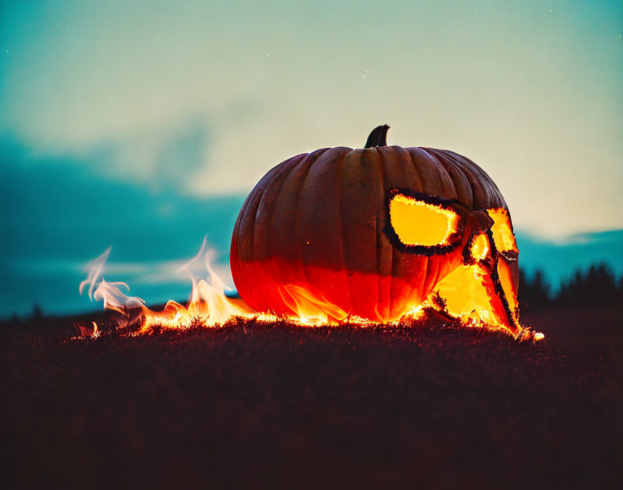 Scary face carved pumpkin with flames at dusk