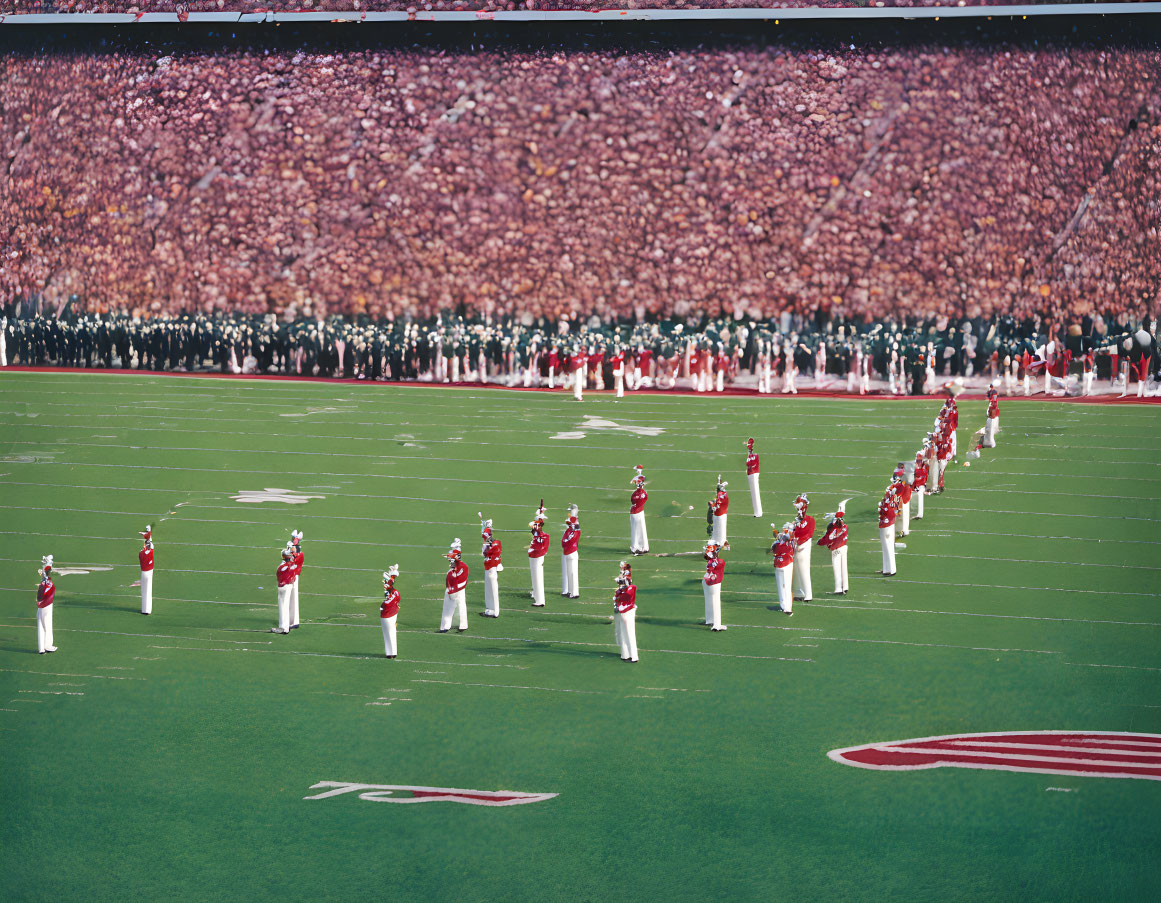 Red uniformed marching band performs on football field