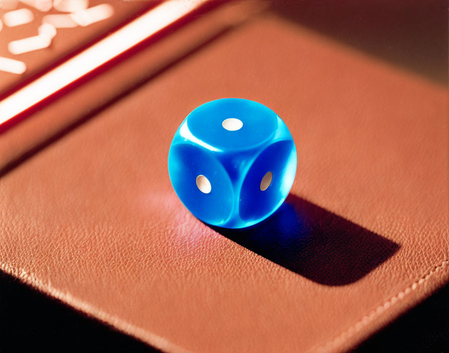 Blue translucent dice with white pips on leather surface in warm lighting