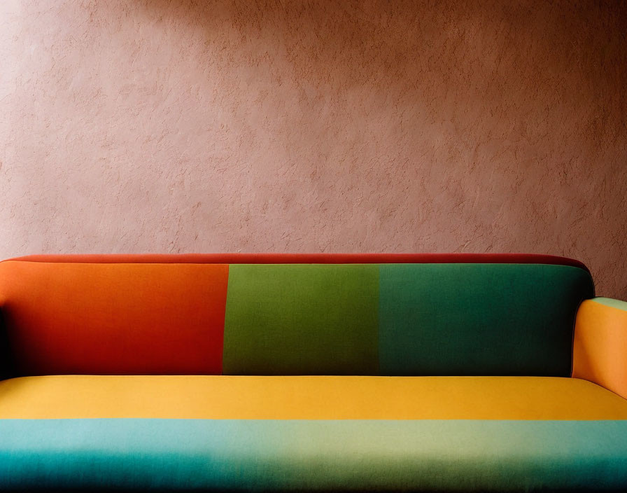 Colorful Sofa with Red, Green, and Blue Pattern Against Textured Pink Wall