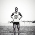 Muscular man in tank top and shorts in desert landscape under hazy sky