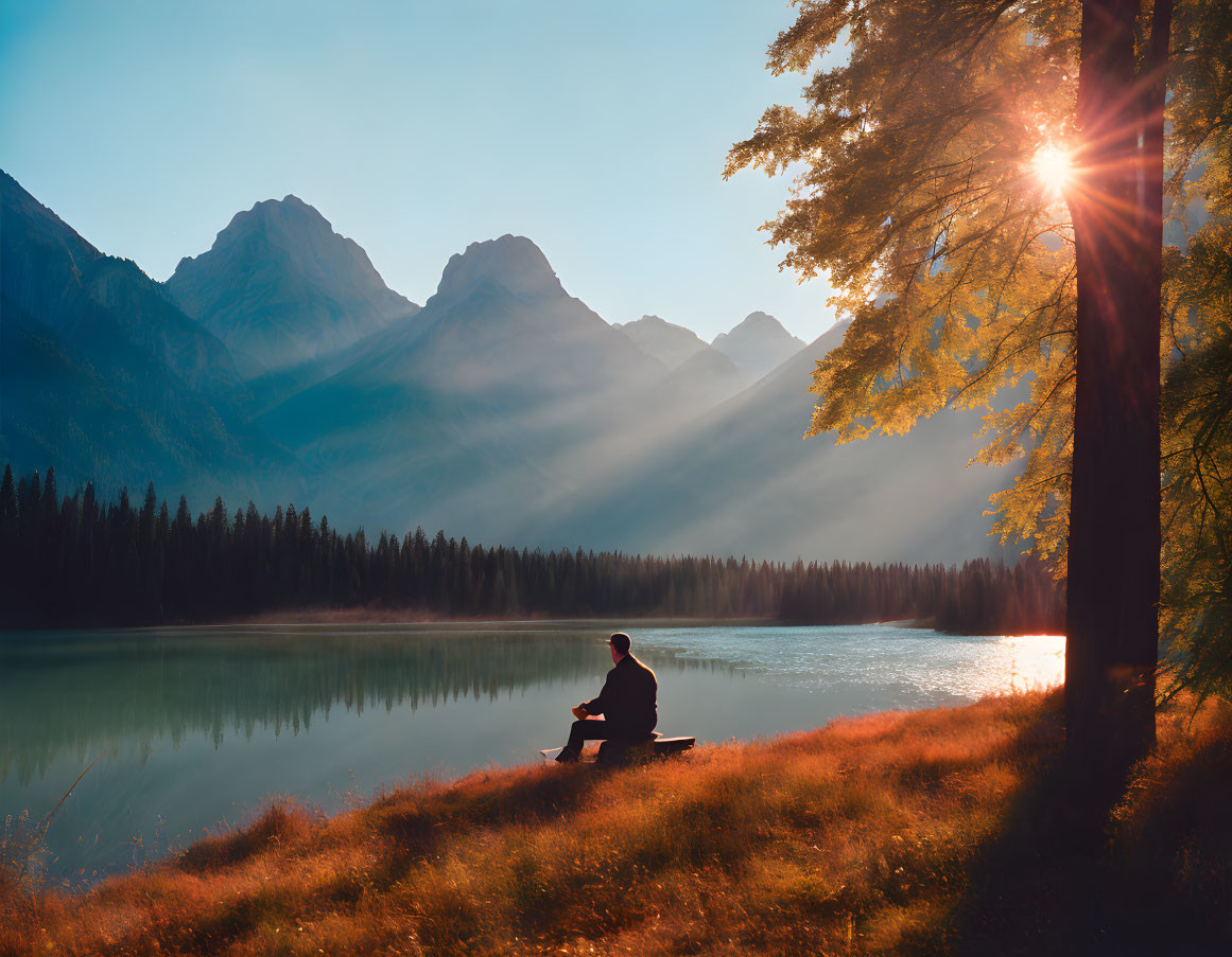 Solitary figure by tranquil mountain lake at sunrise