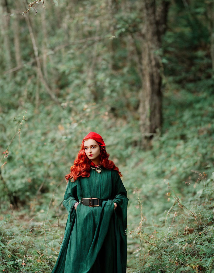 Red-haired person in green medieval cloak and red hood in forest setting