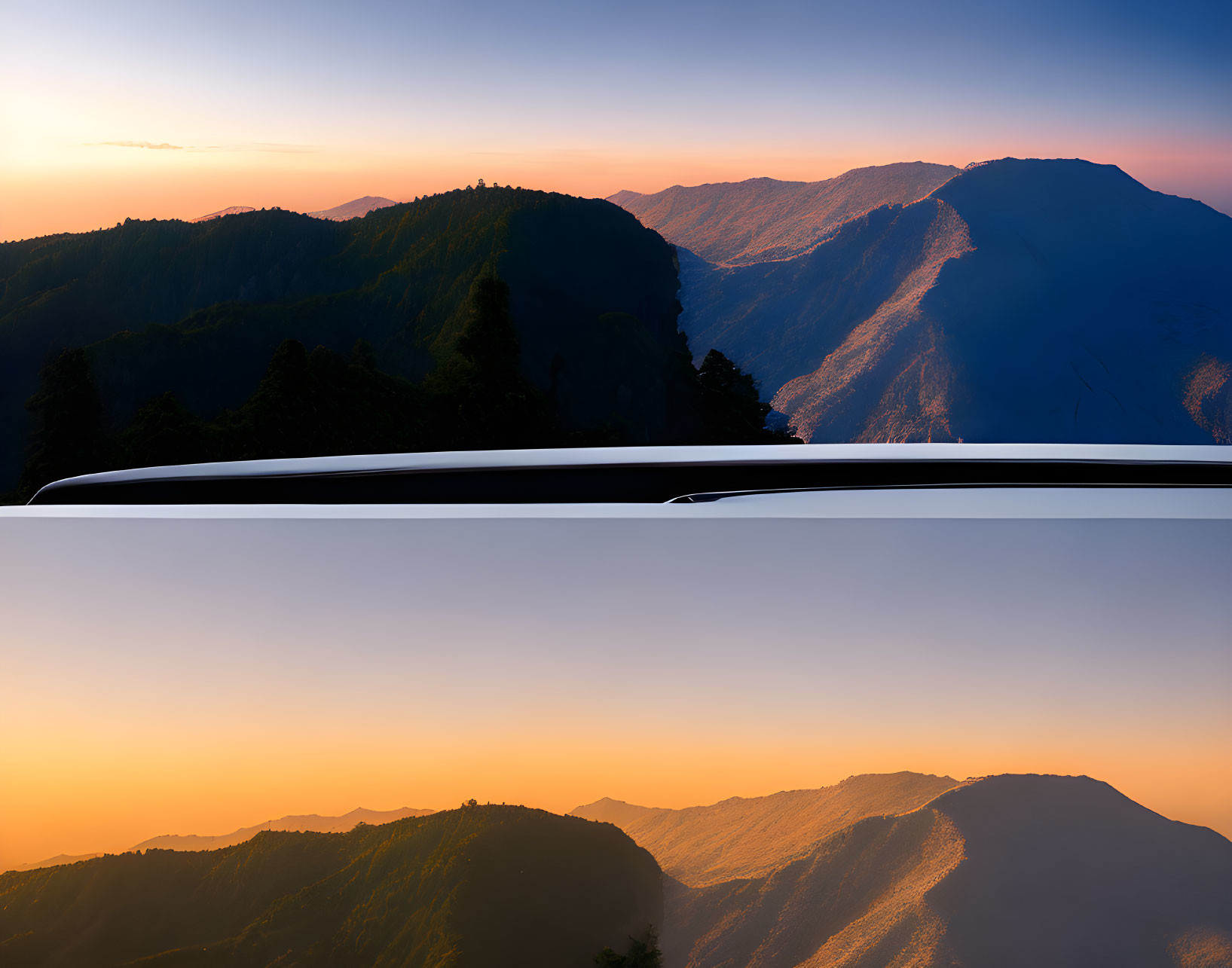 Scenic sunset over mountain ranges from car roof