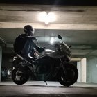 Motorcyclist in full gear on sportbike in dimly lit parking garage