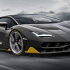 Black Sports Car with Yellow Accents Against Snow-Capped Mountains