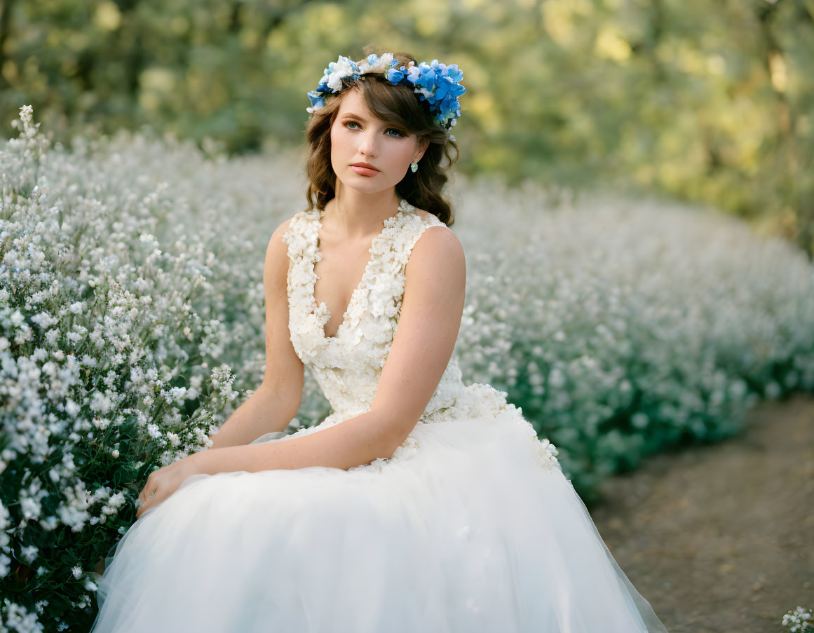 Woman in floral headpiece surrounded by blooming white bushes in serene setting