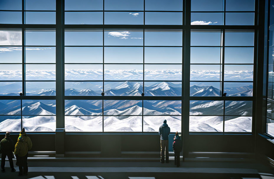 Modern building interior with large windows showcasing snowy mountain peaks under clear blue sky