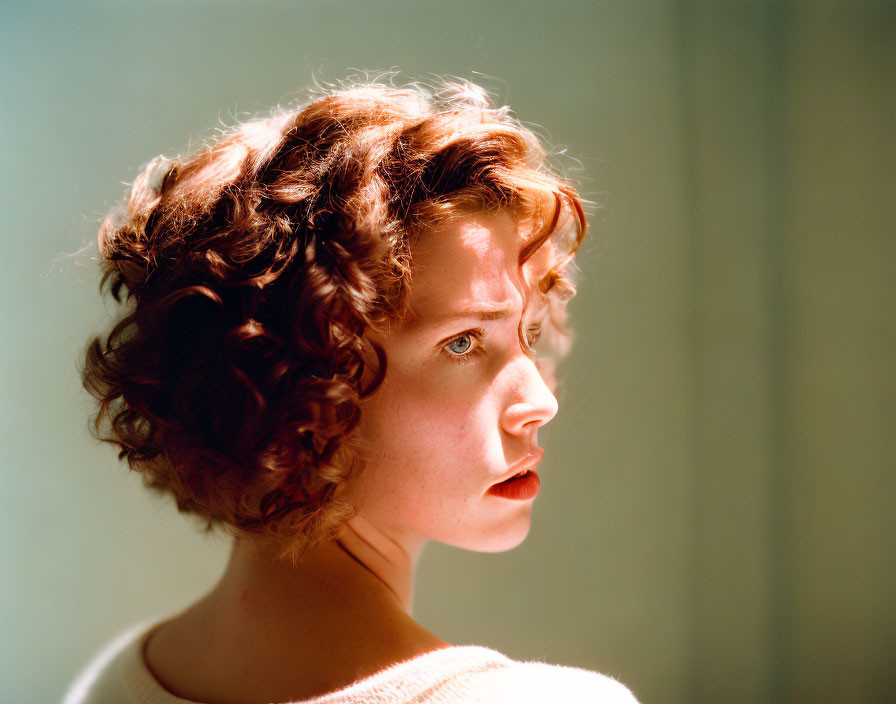 Curly-haired woman looking left in gentle light