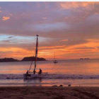 Tranquil sunset beach scene with vibrant sky and distant island