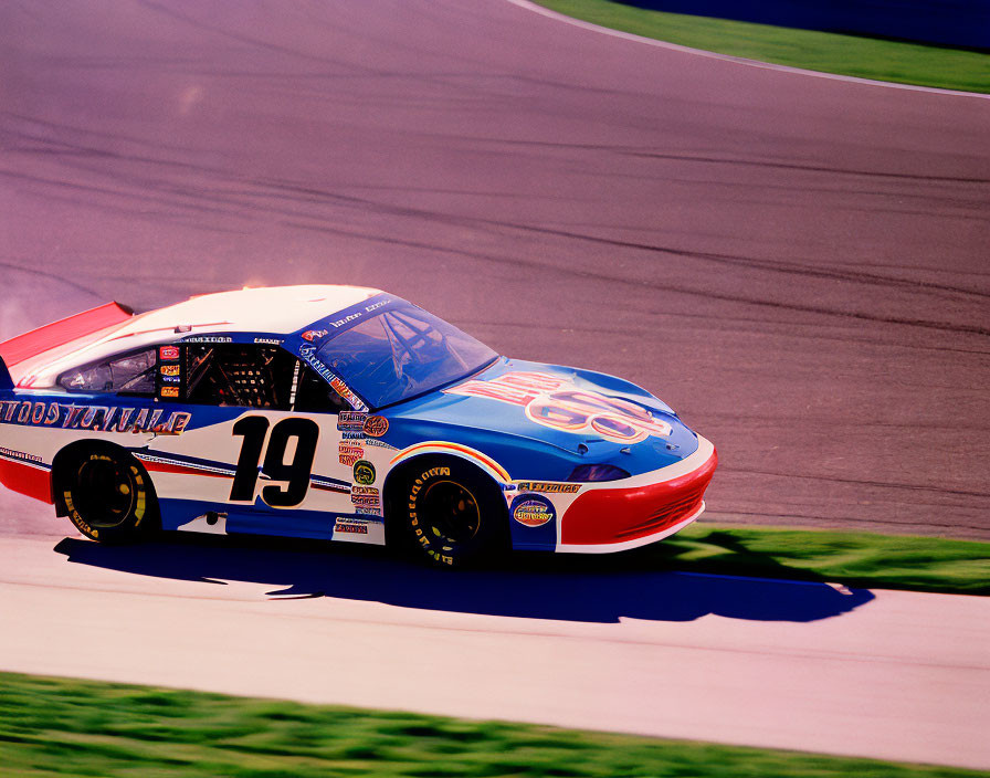 Blue and Red Number 19 Stock Car Speeding on Race Track