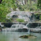 Tranquil forest scene: waterfall over mossy rocks