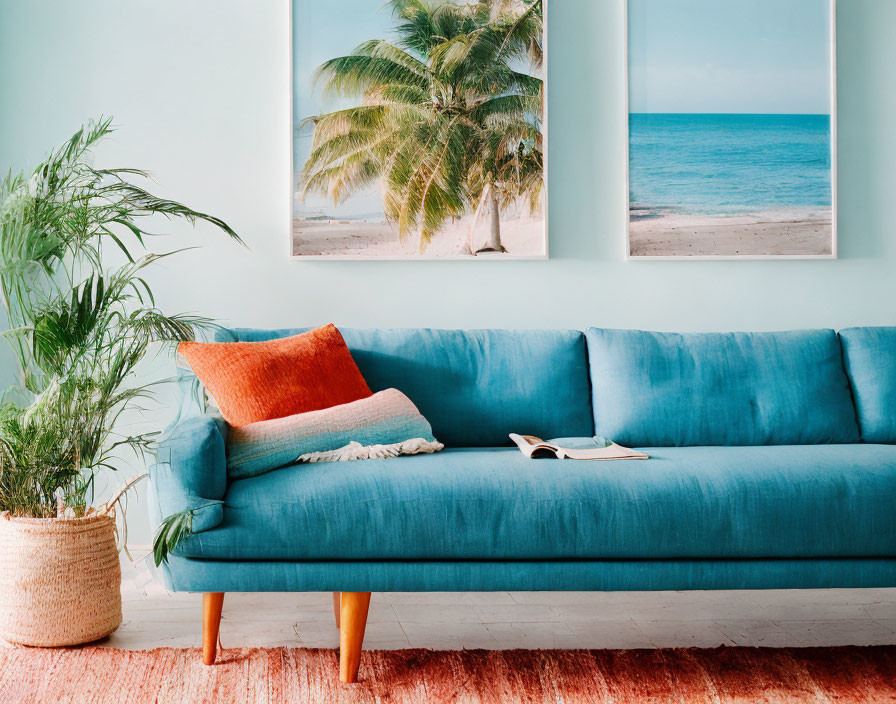 Vibrant interior with blue sofa, orange pillow, plant, and beach-themed wall art