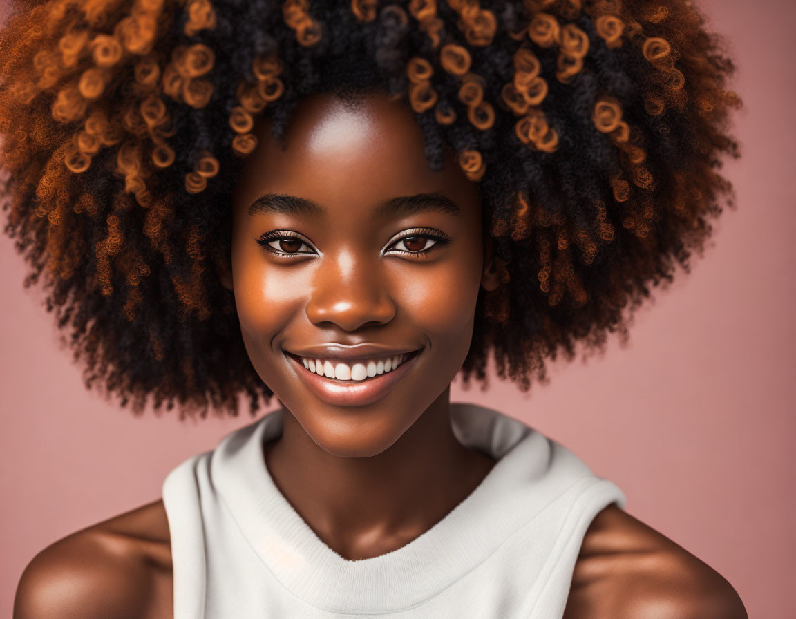 Smiling woman with radiant skin and curly afro hairstyle on peach background