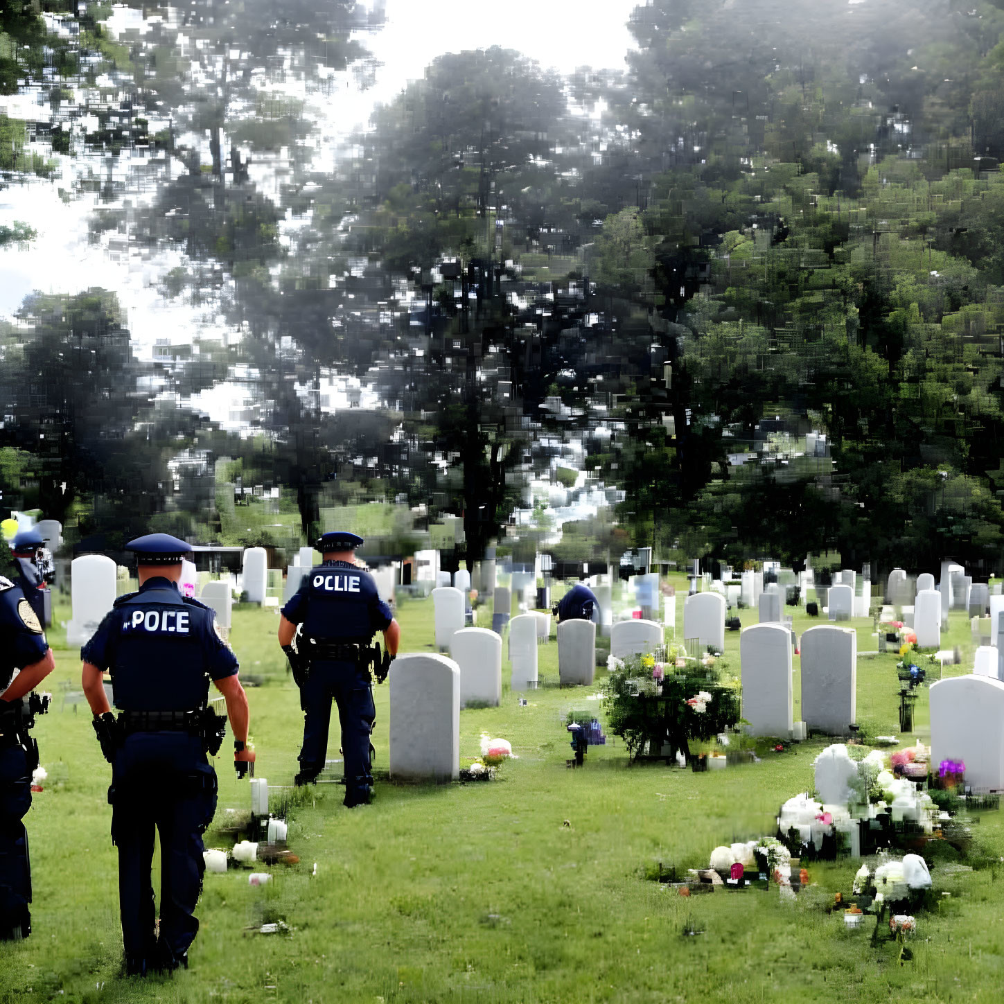 Police officers in cemetery among headstones with flowers