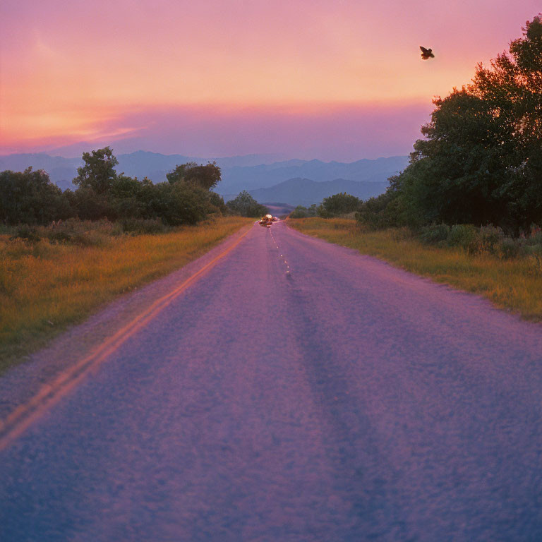 Tranquil sunset scene with pink and purple hues over quiet road