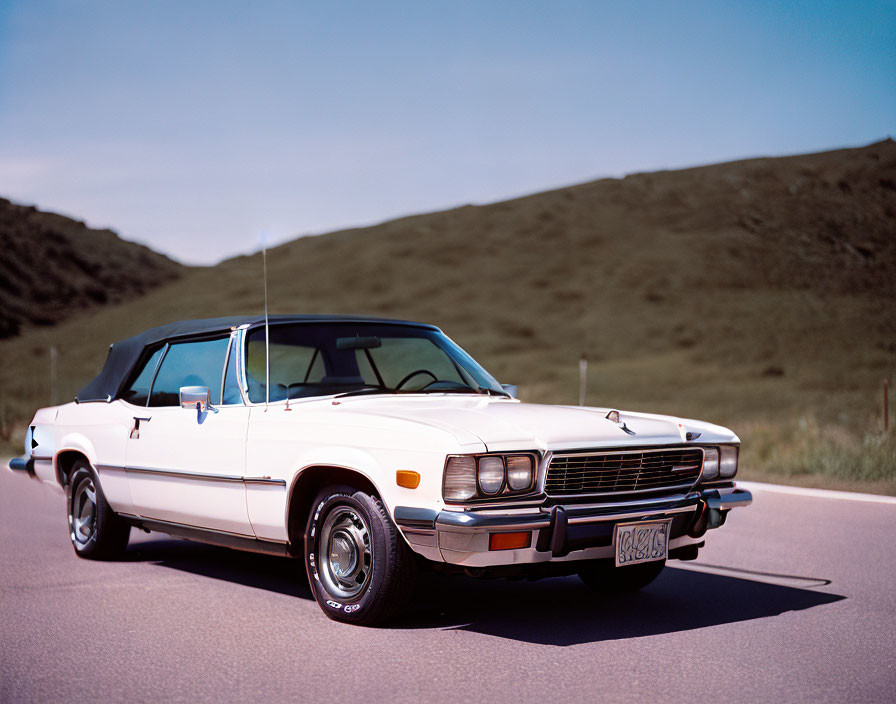 Classic White Convertible Car Parked on Road with Grass Hill