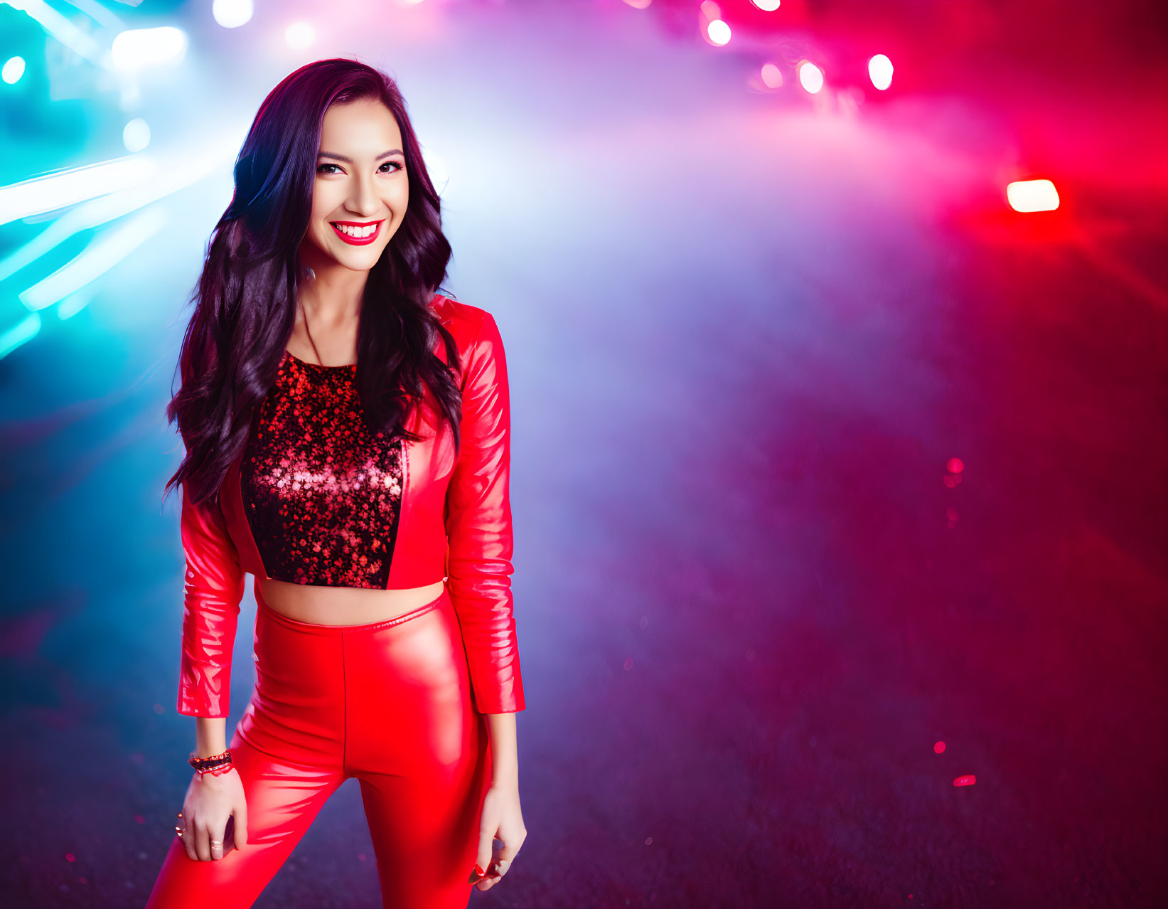 Smiling woman in sparkling top and red leather jacket on vibrant background