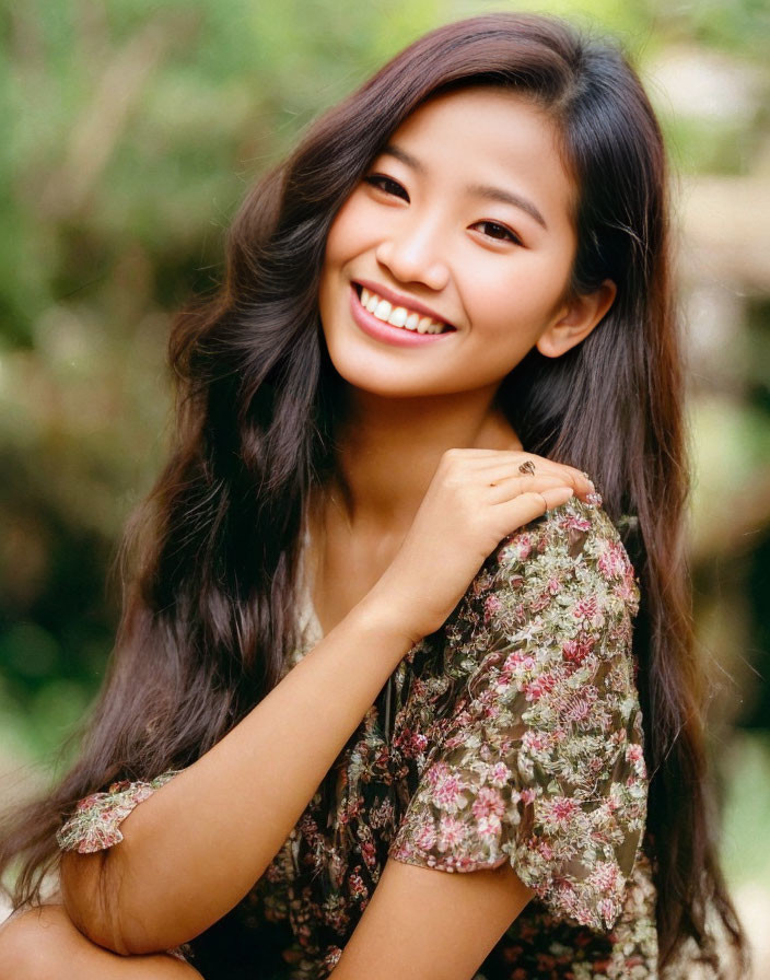 Smiling woman in floral dress with wavy hair on green background