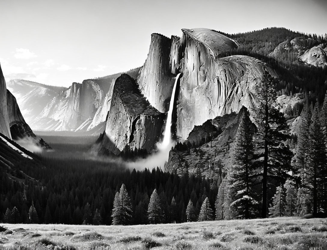 Monochrome photo of Yosemite Valley with El Capitan, waterfall, Half Dome, forest, and mist