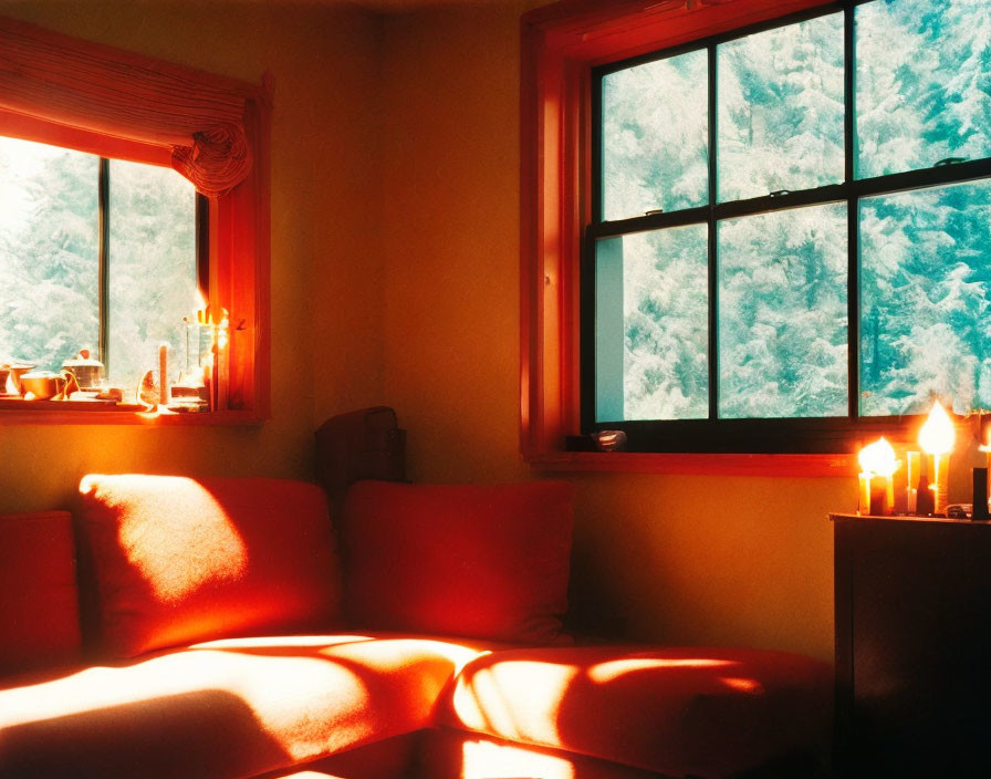 Warm Candlelit Room with Red Sofa & Snowy Tree View