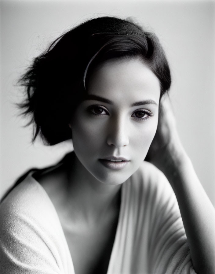 Monochrome portrait of woman with short hair, hand on head