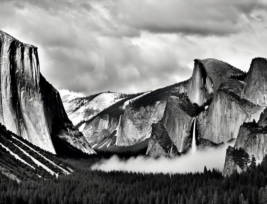 Monochrome landscape of mountain cliffs, waterfall, forest, and dramatic sky