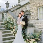 Wedding couple embracing on staircase with flowers in watercolor