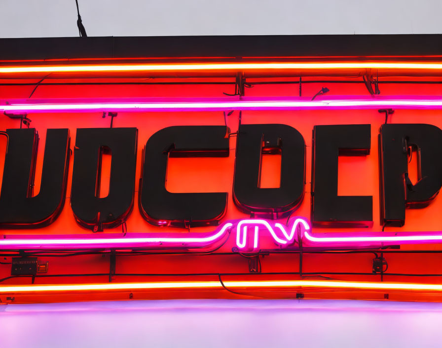 Vibrant neon sign with pink and orange glow, mirrored letters, white and purple elements.