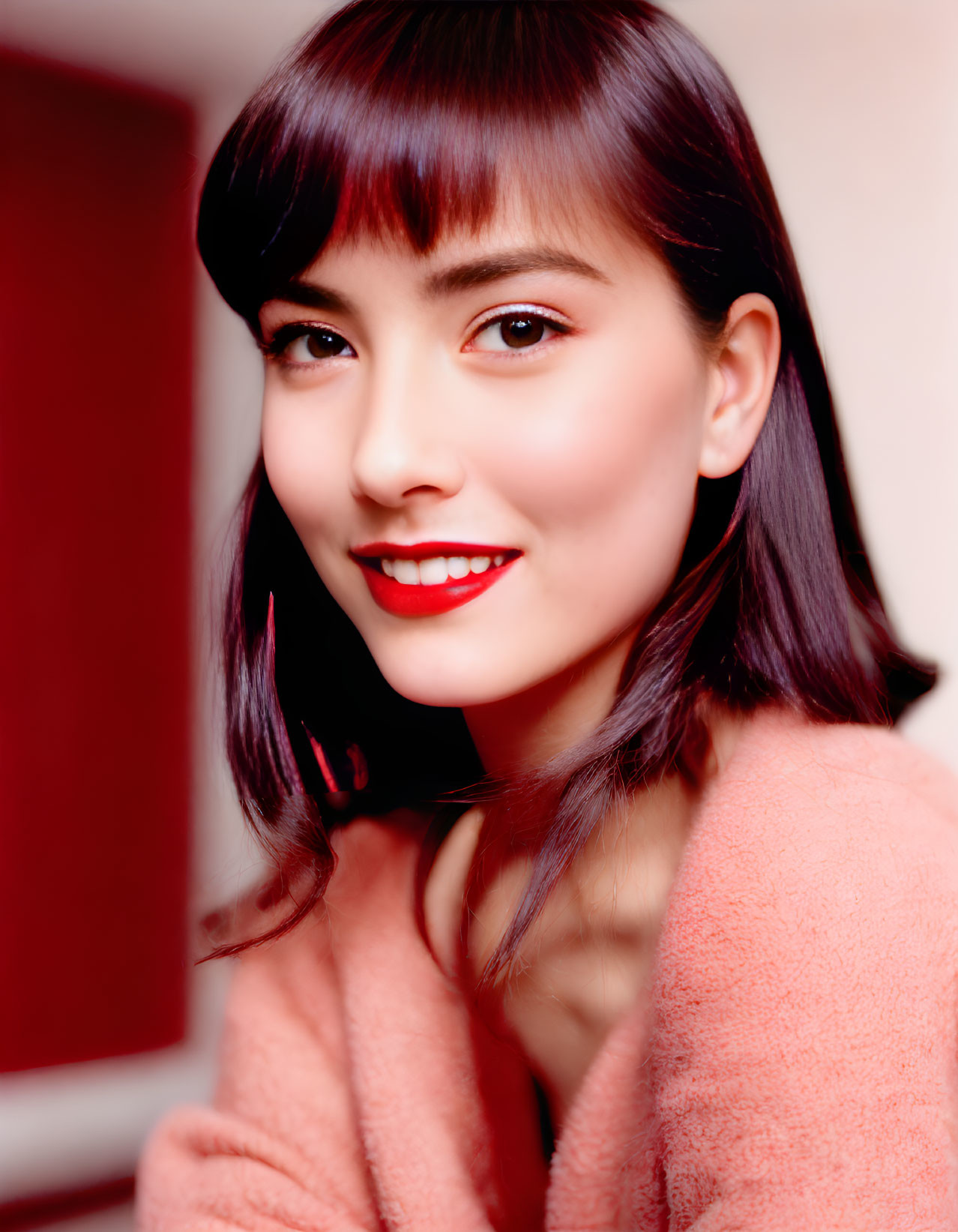 Woman with Dark Hair and Red Lipstick Smiling in Pink Outfit