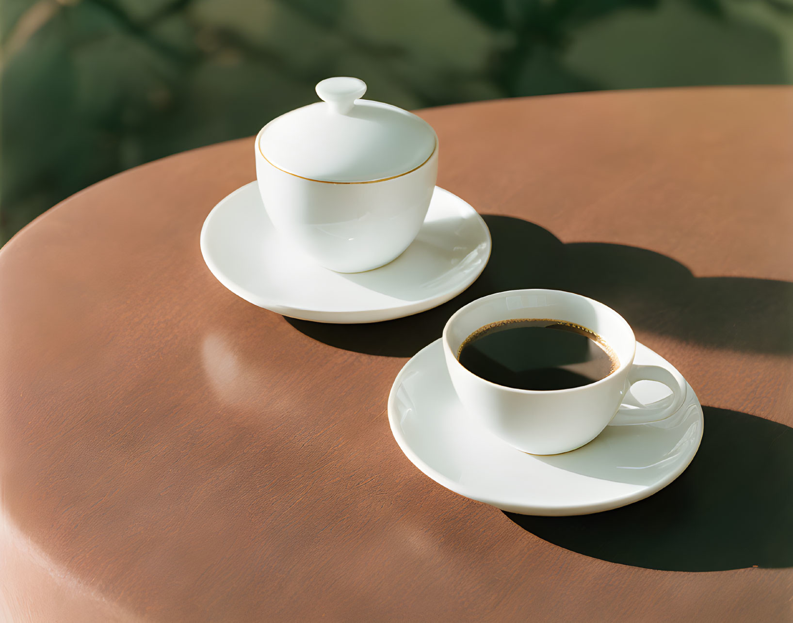 Black Coffee Cup, Saucer, and Sugar Bowl on Round Table in Soft Sunlight