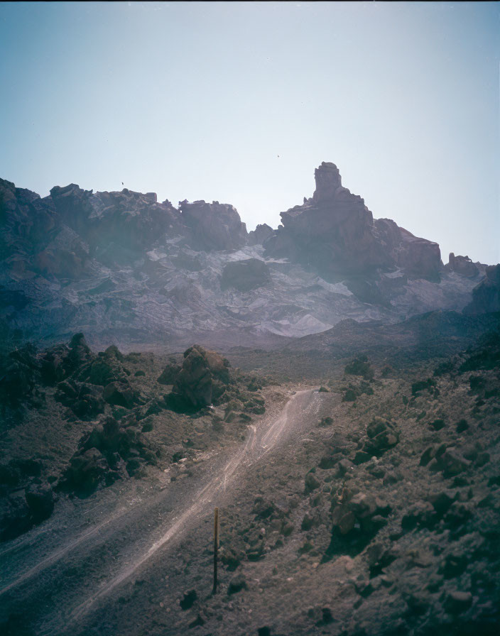 Desolate landscape with rugged dirt road and rocky terrain